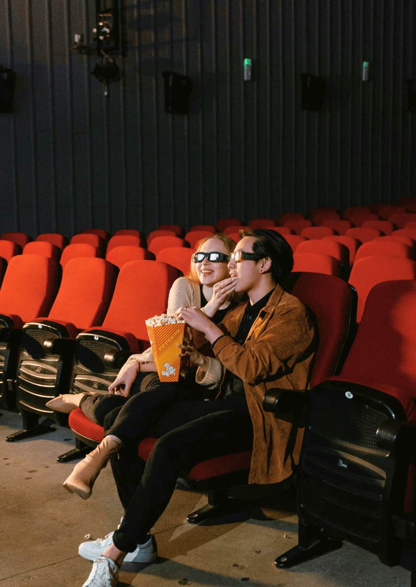 couple sharing popcorn in a movie theater