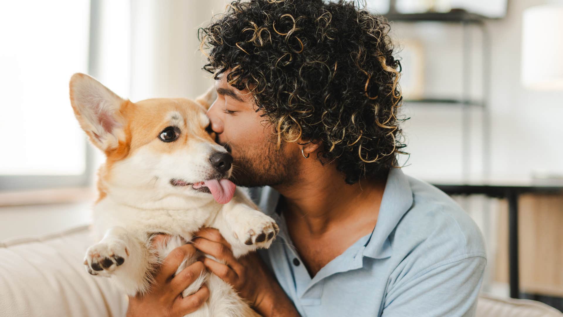 attentive man kissing dog lovingly