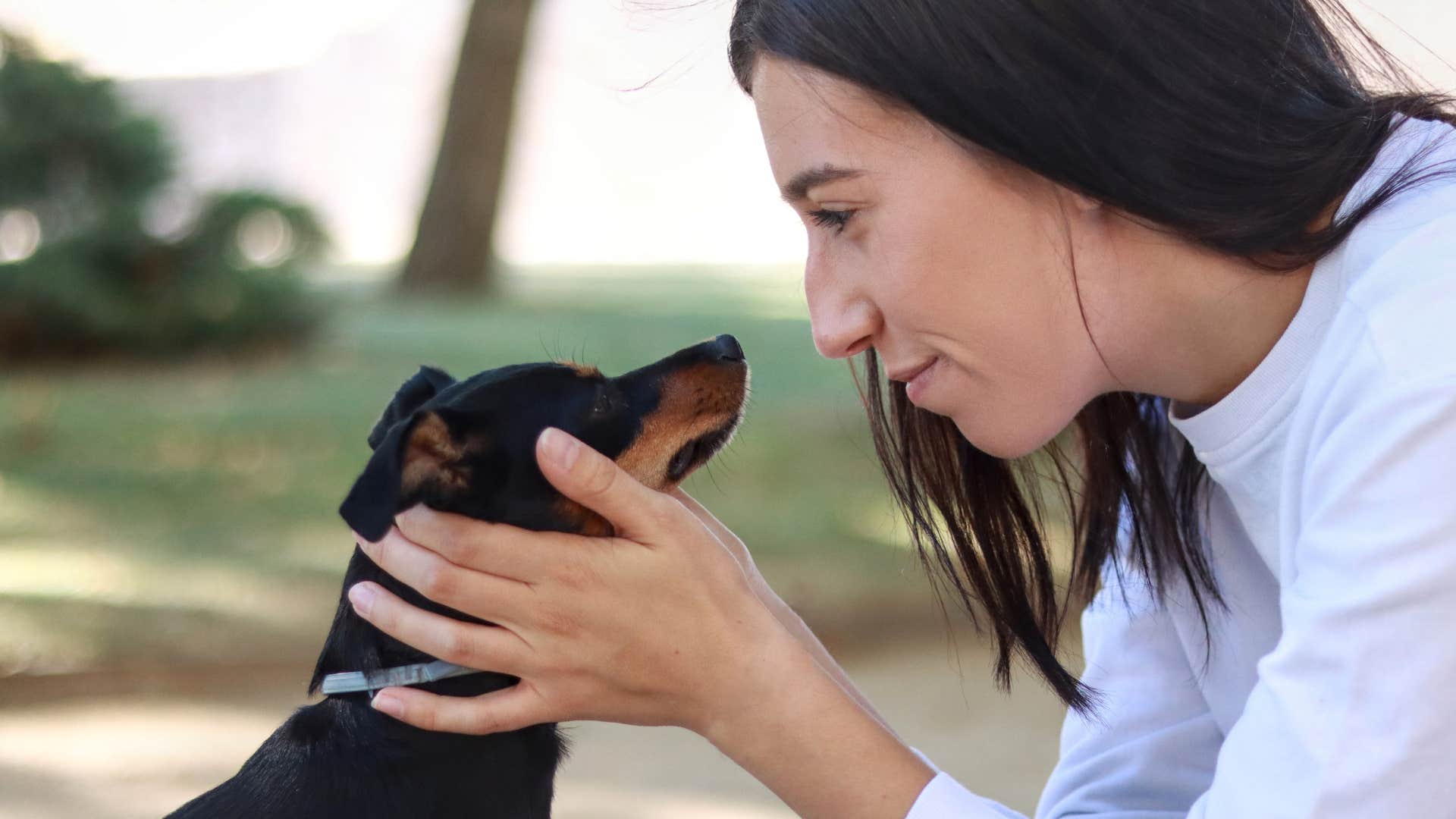 empathetic woman holding dogs face
