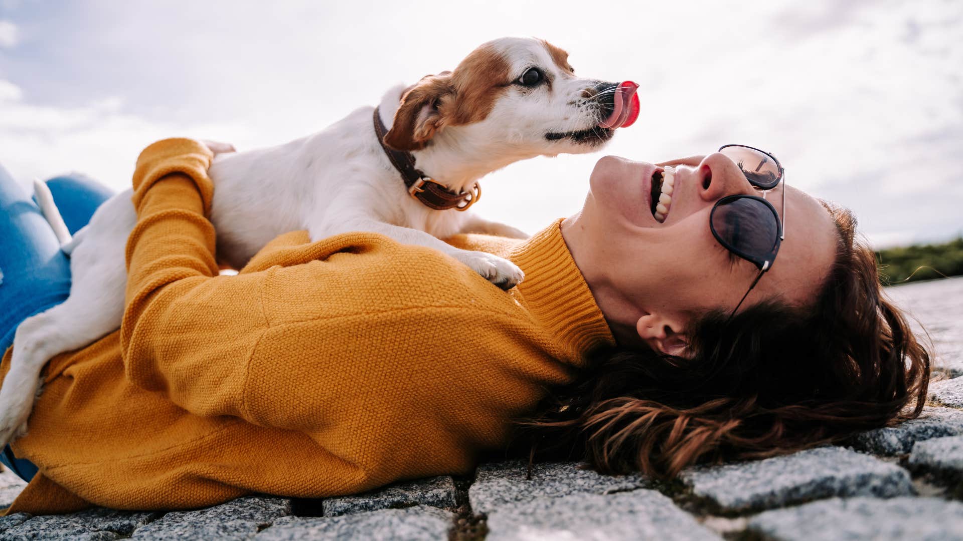 dog laying on smiling woman outside