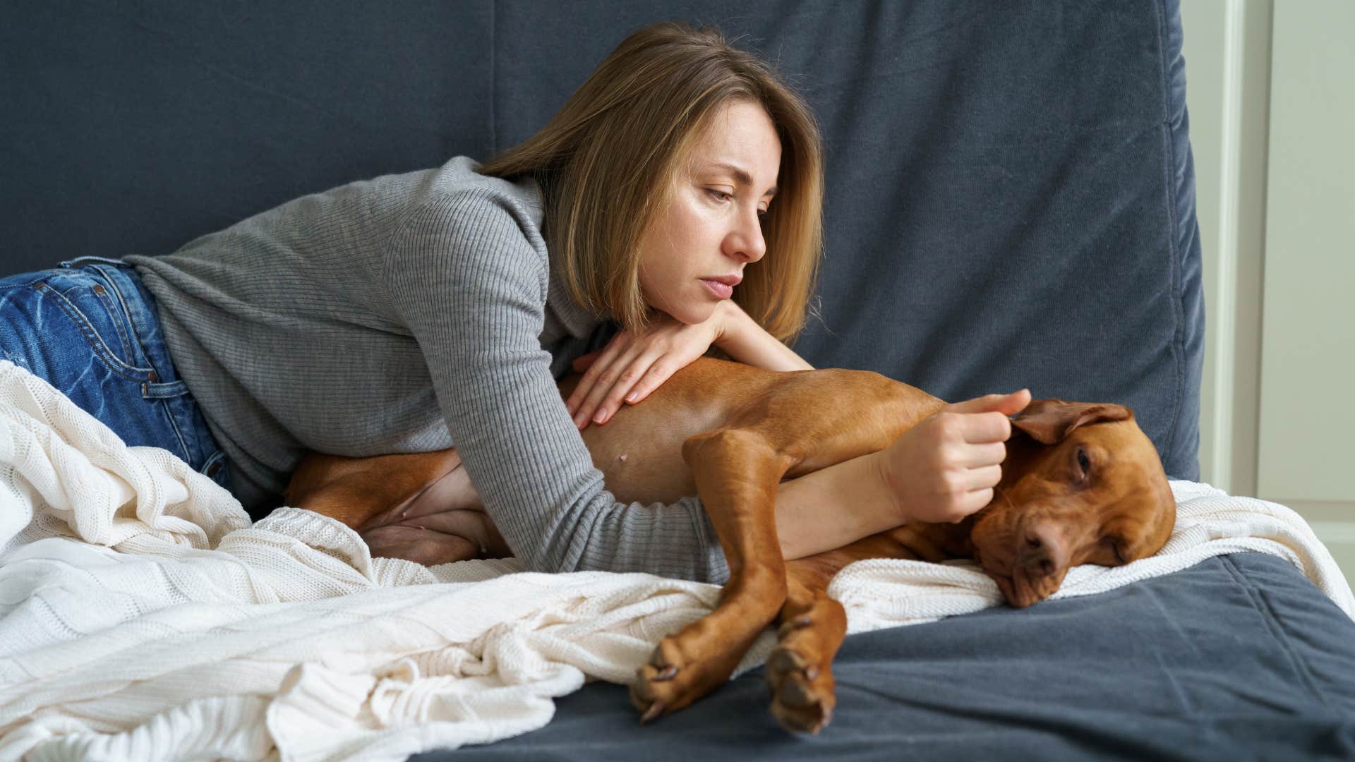 patient woman petting sleeping dog 