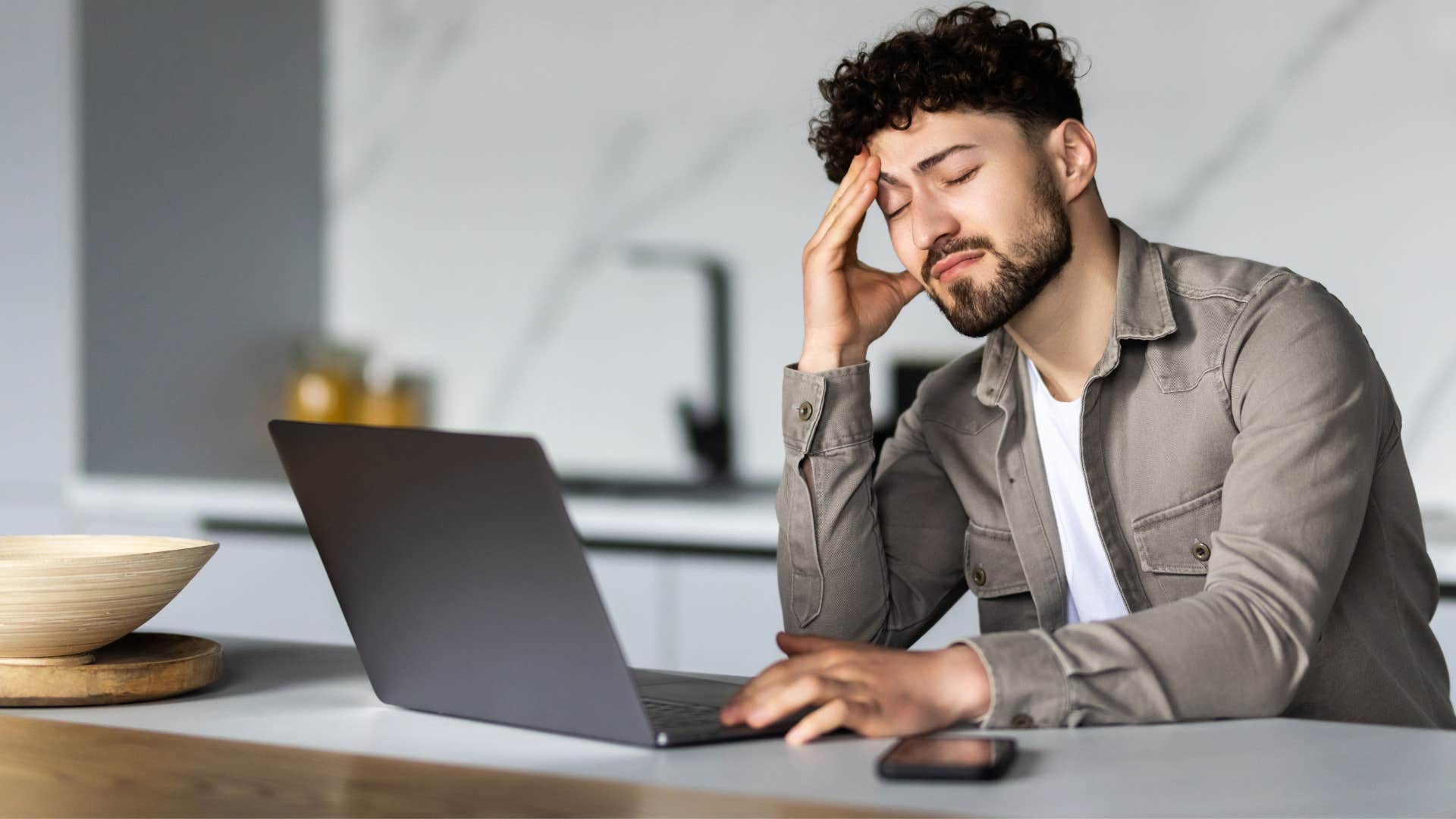 man frustrated in loud environment trying to think