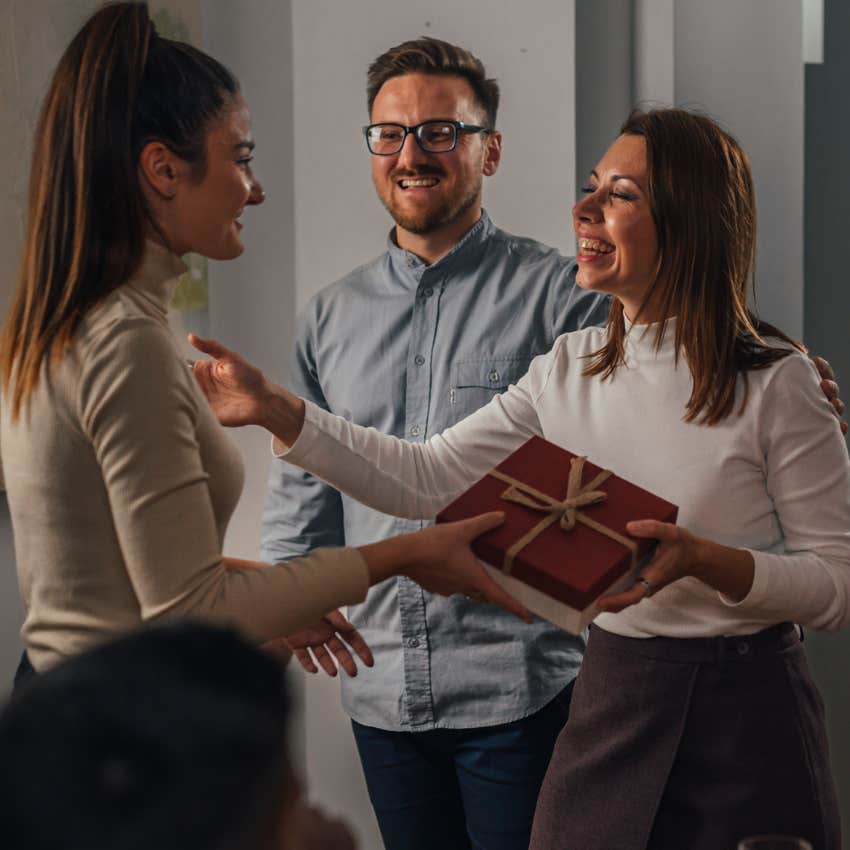 woman smiling bringing a gift for the host of a party