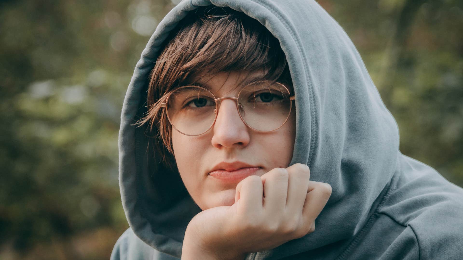 teen boy sitting outside expected to be the example child
