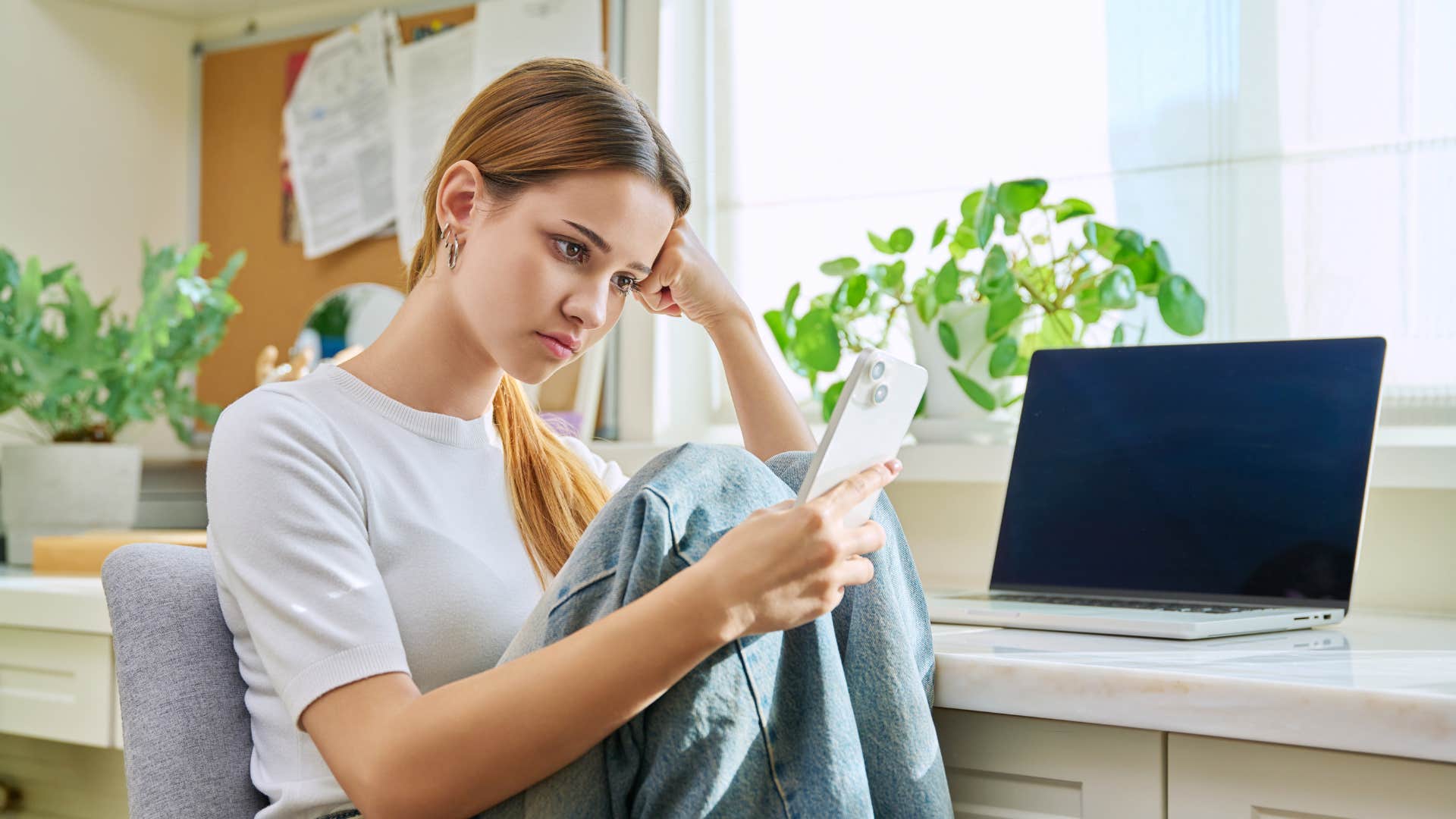 teen girl sitting at desk in front of laptop solving problems