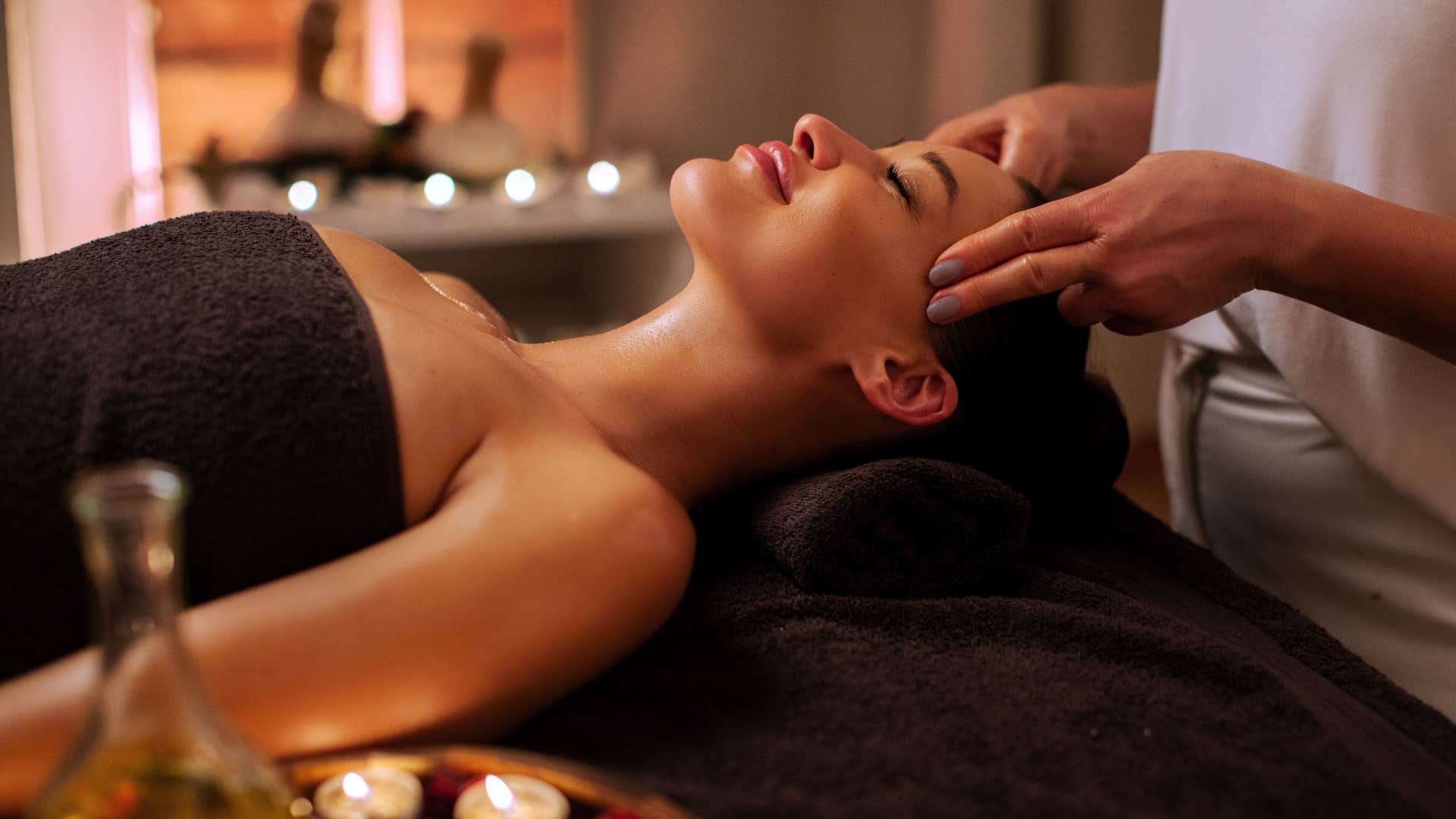 Blissful person on vacation gets body work from masseuse