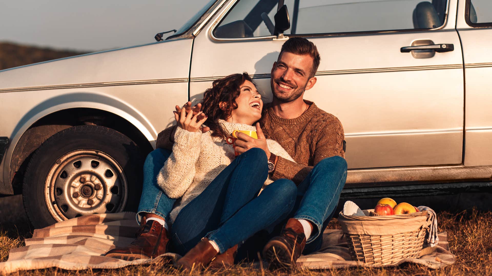 Happy couple on vacation enjoy roadside picnic