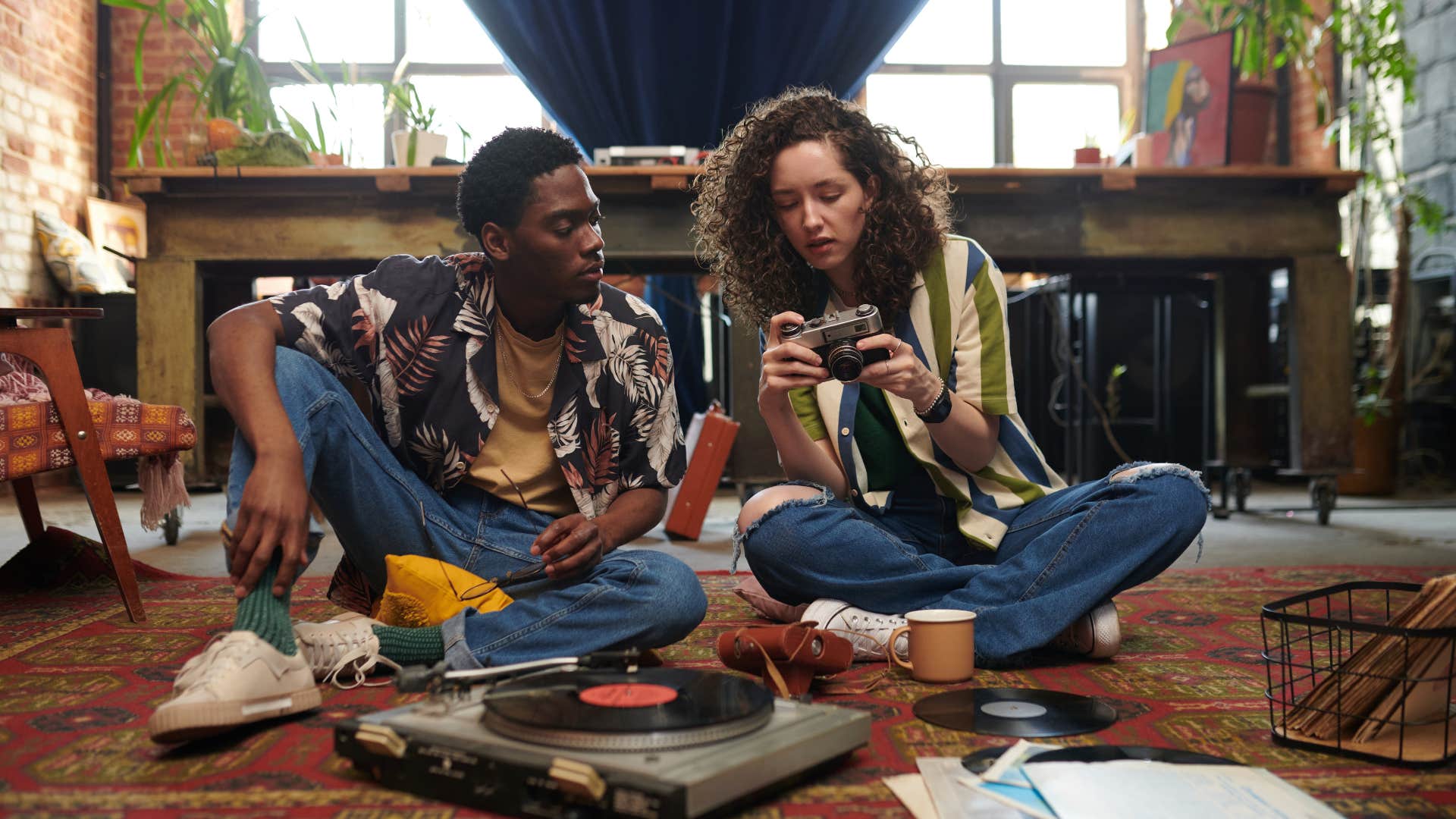 creative man showing woman his record collection
