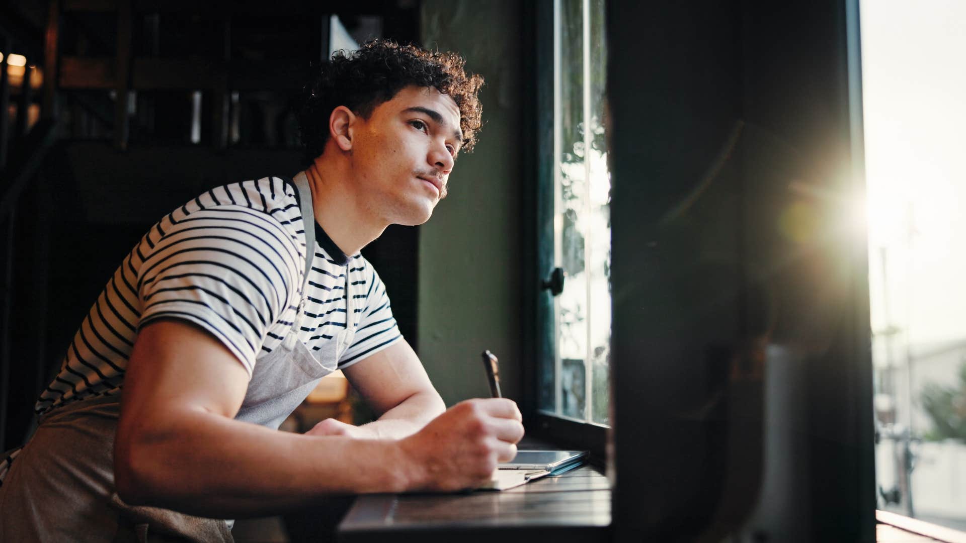creative focused man planning a party writing in notebook