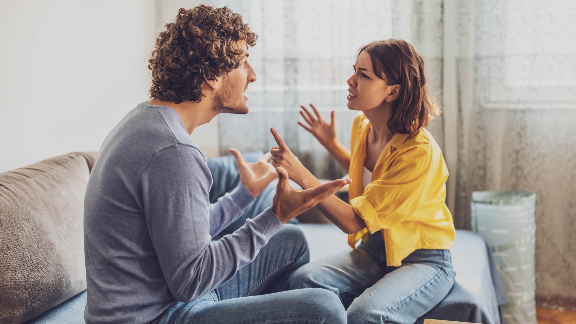 couple arguing on bed as man joked about private struggles or vulnerabilities
