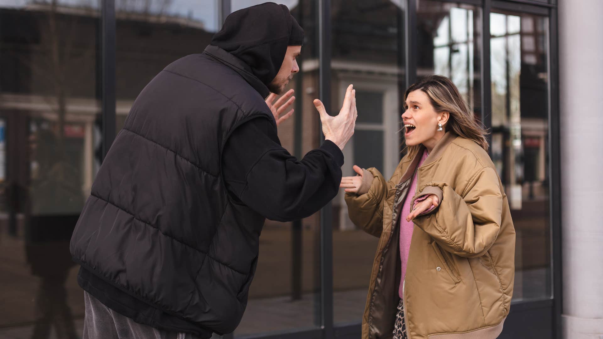 man and woman arguing outside as man joked about their spouse's family background