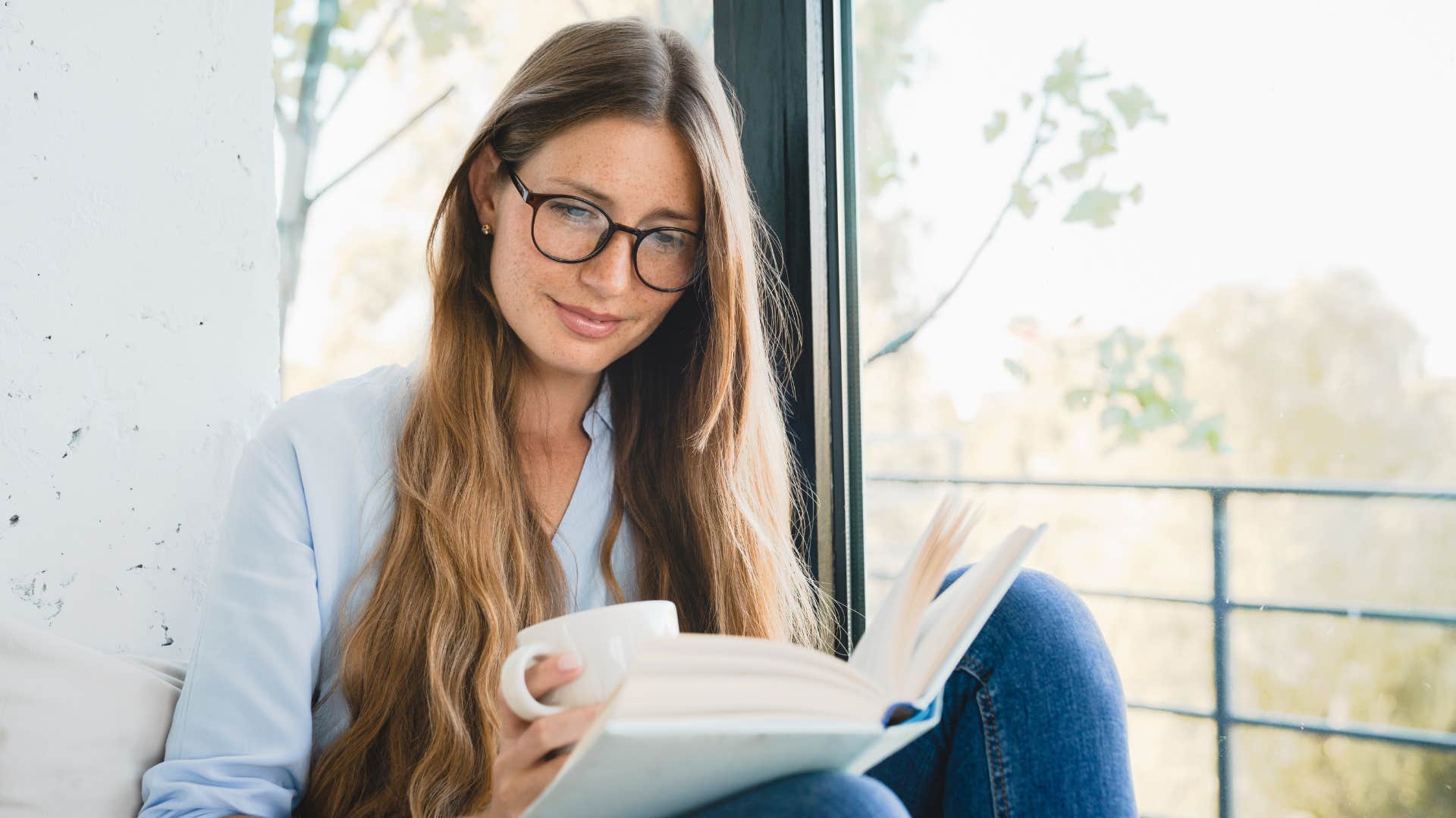 woman reading book as man joked about their spouse's intelligence