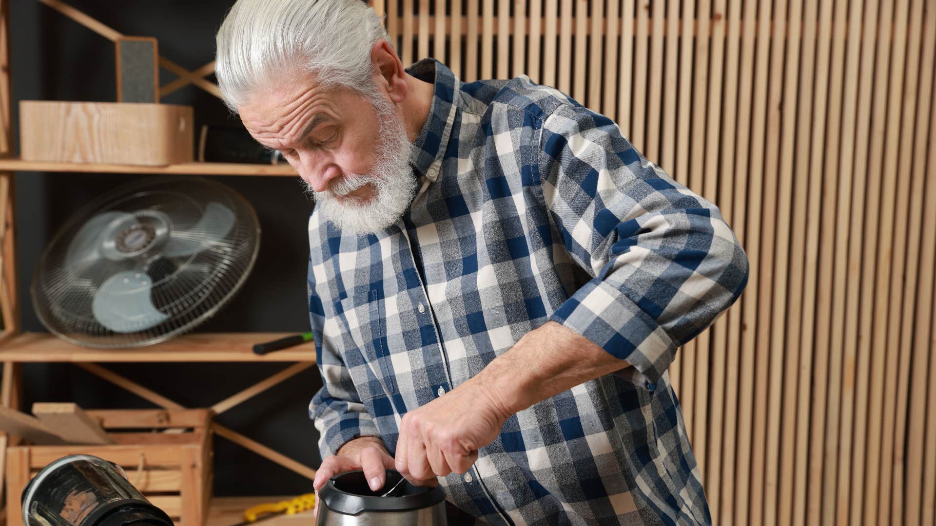 older grandpa fixing small gadgets and toys in the garage