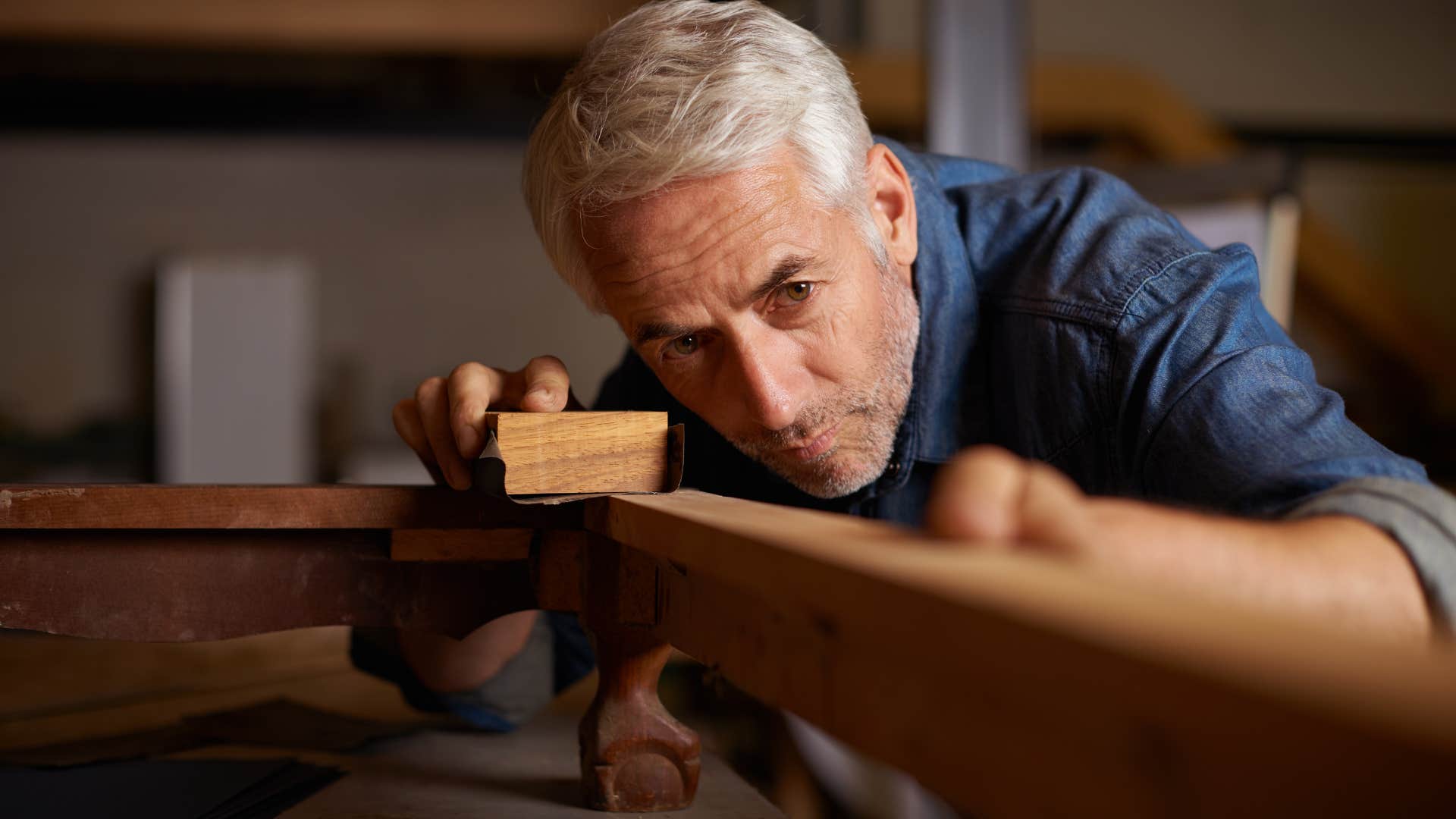 older man woodworking in his garage at home