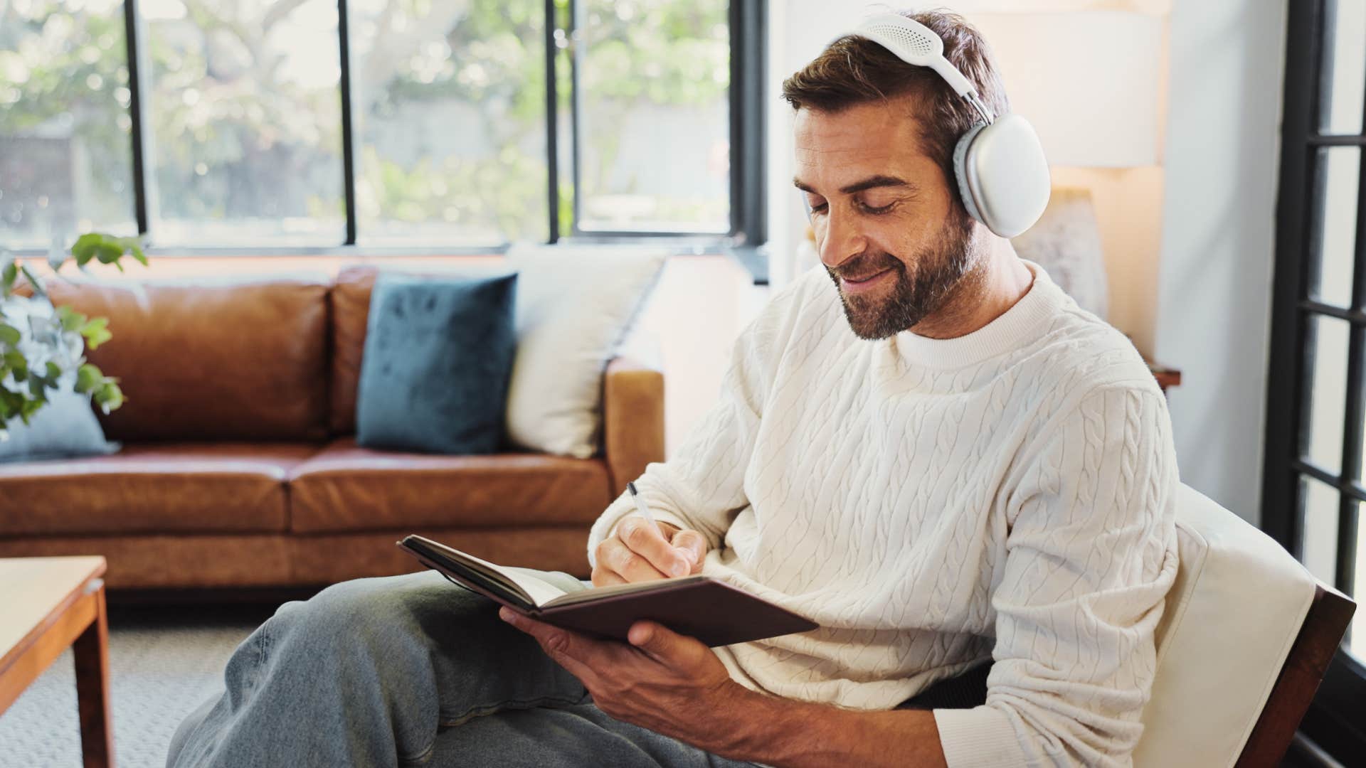 thoughtful man journaling while listening to music