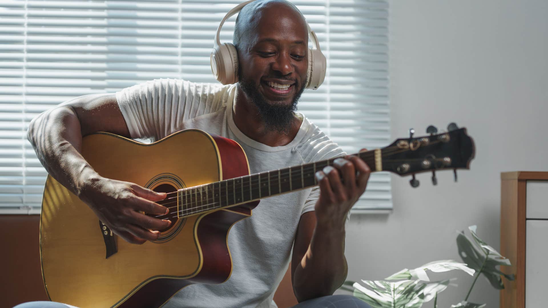 talented man playing a guitar at home