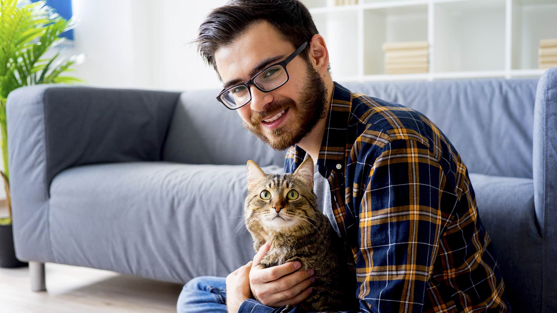 good man smiling taking care of his pet cat