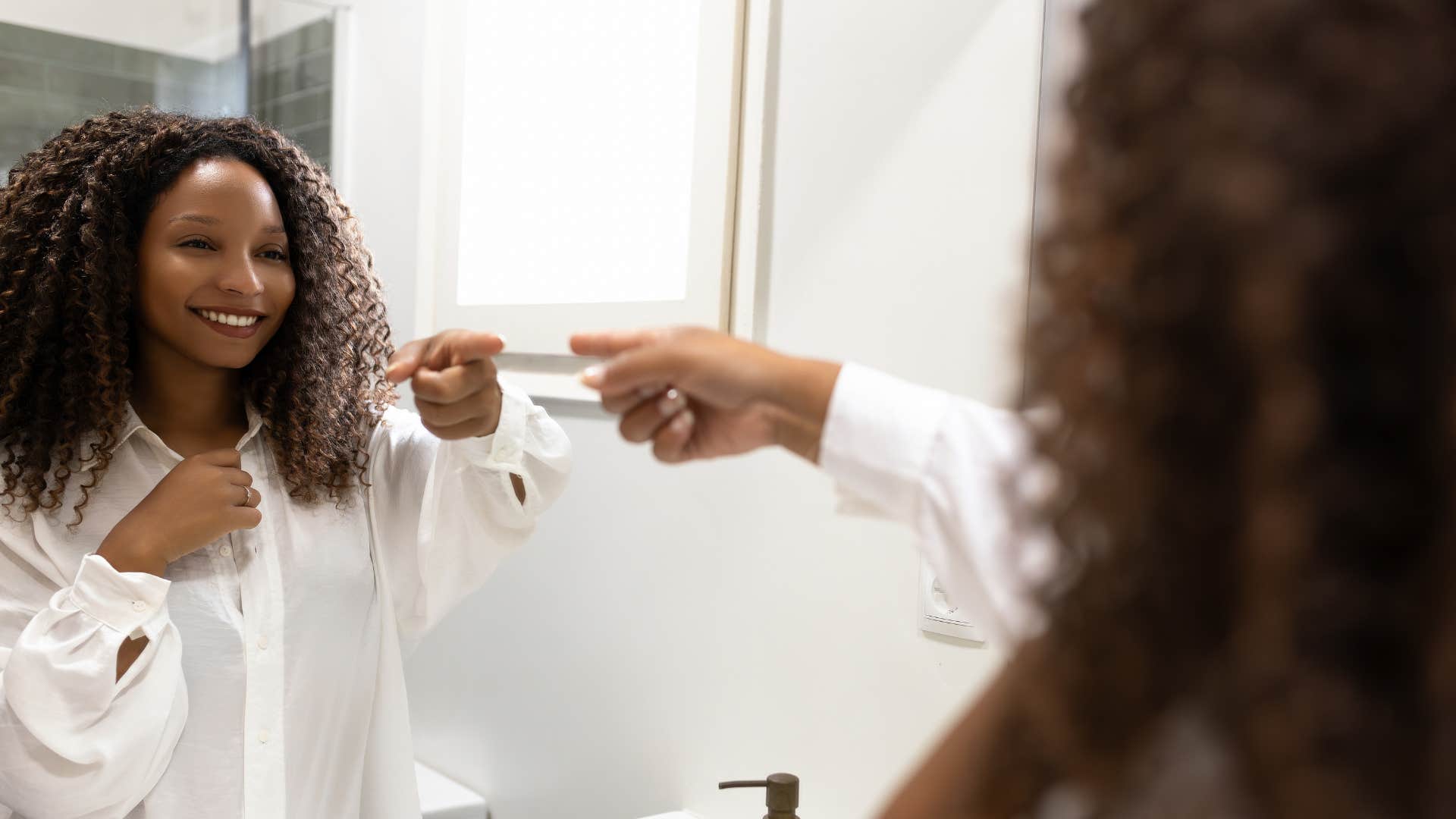 Confident perosn points in mirror showing high-quality people know their worth