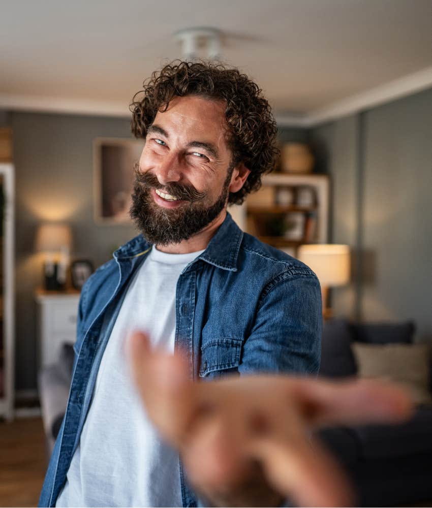 Over enthusiastic man extends hand showing low quality game player 