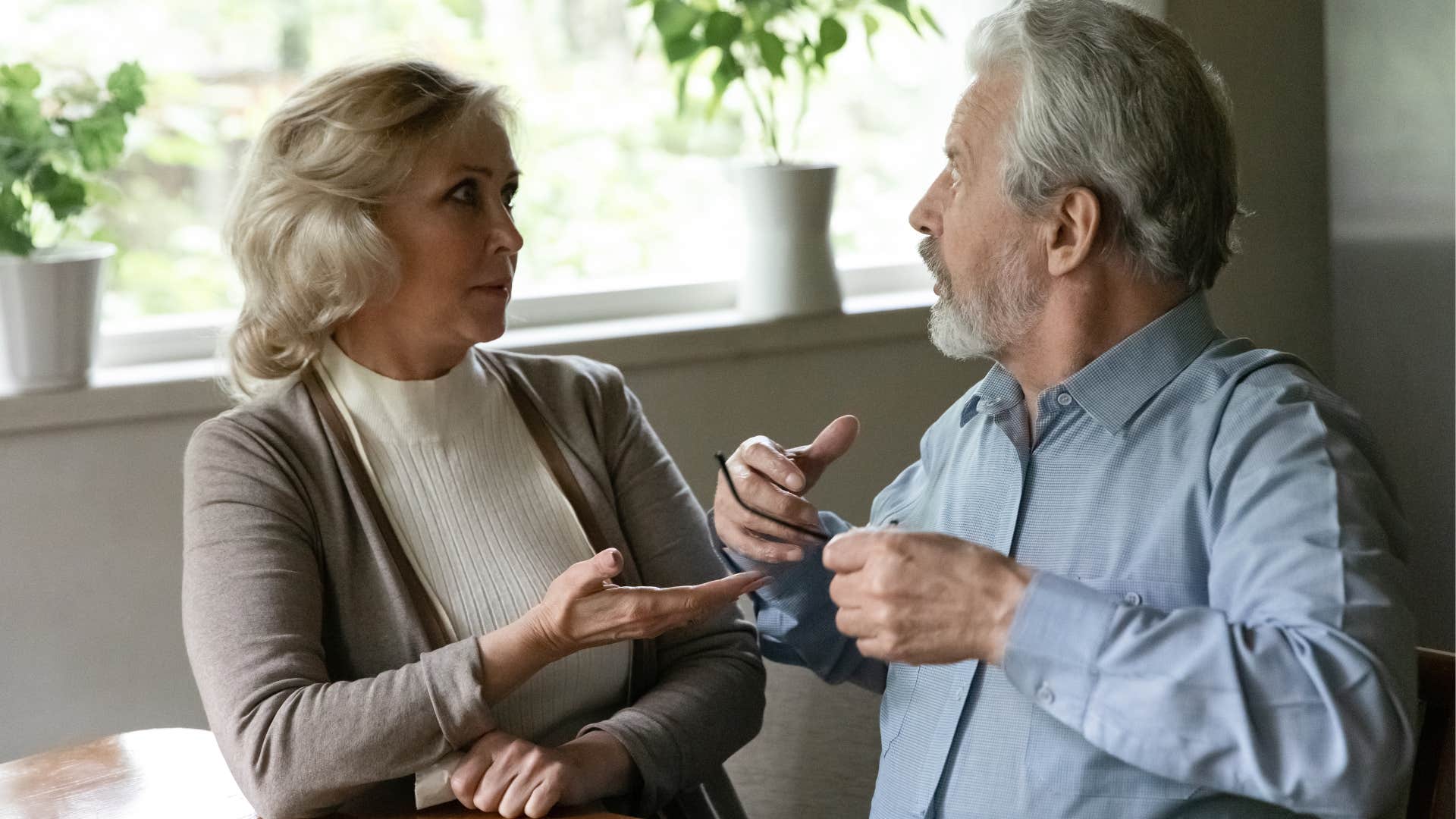 couple arguing with man saying why can't you just let it go to his wife