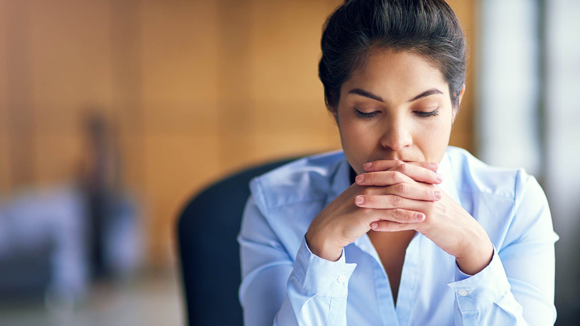 worried woman thinking at desk after being told to let it go