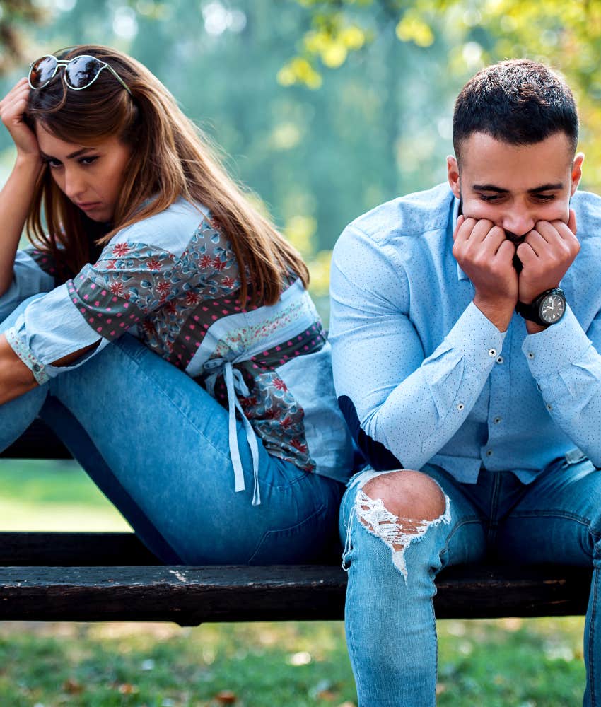 Upset couple sit in silence showing emotional response to not leaving