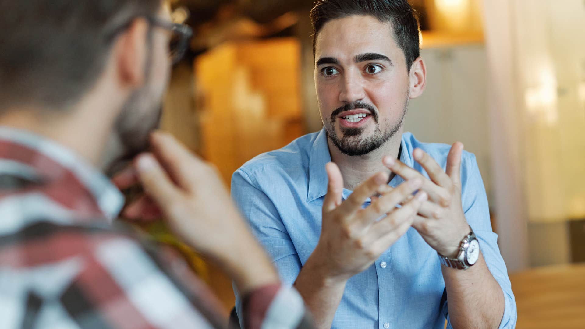 man making small talk with friend feeling stressed doing so