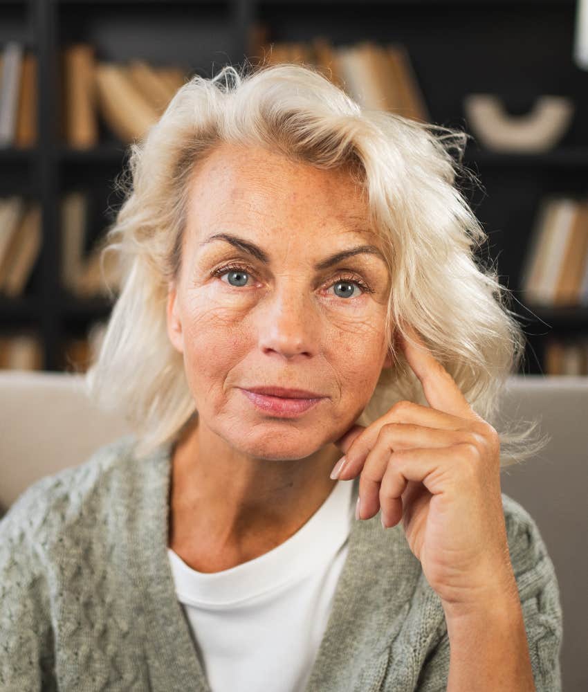 Serious person tocuhes side of head showing past reason you feel down