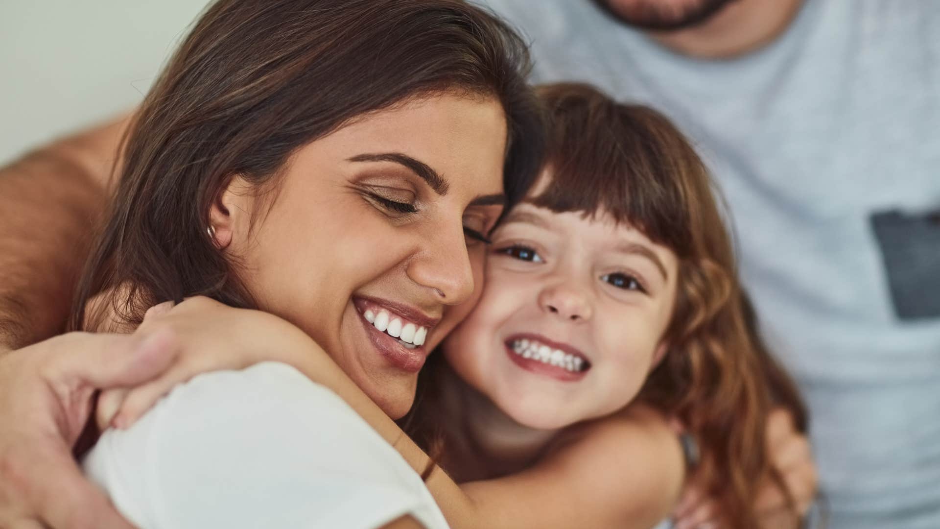 Smiling daughter hugs happy mother showing change forever