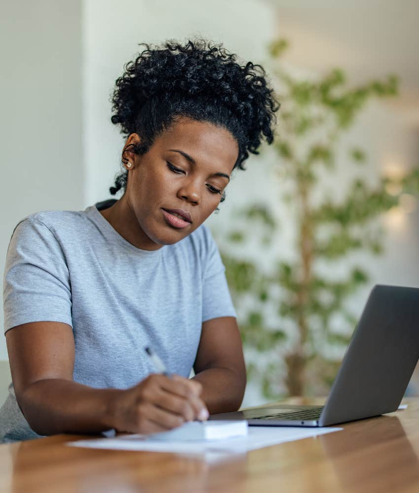 Serious person with laptop and papers showing preparation to manifest happier life