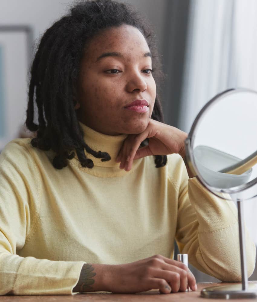 Calm person looks in mirror showing acceptance in clear decisions