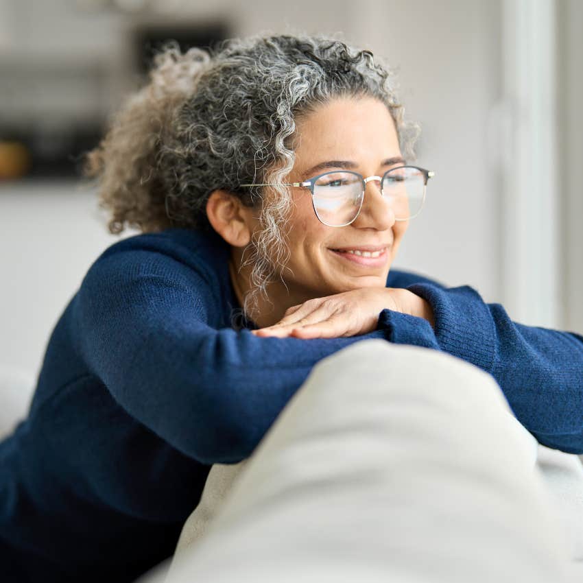 Self-aware woman smiling at home