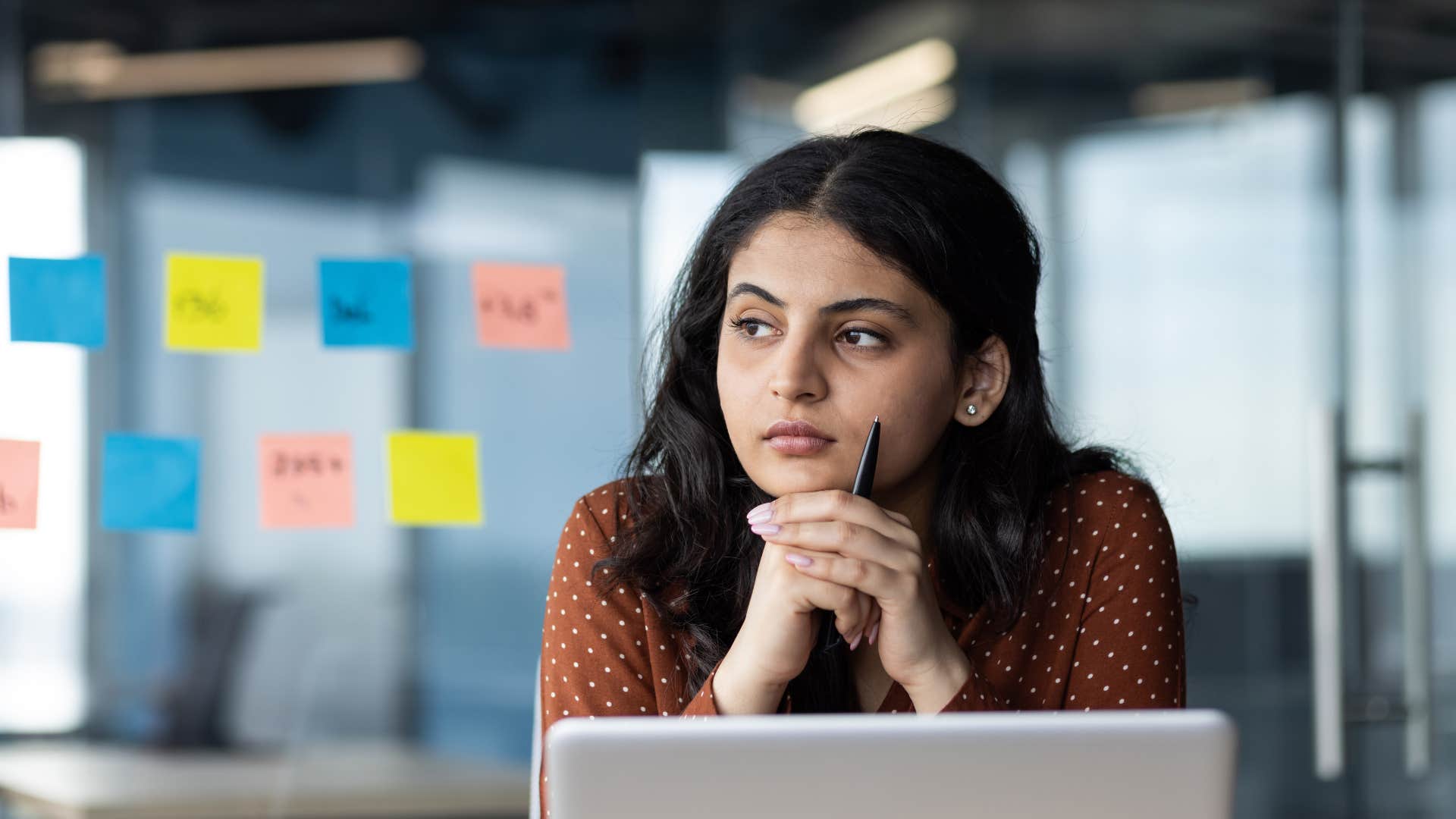 woman thinking at desk after being told i assumed you were handling that at work