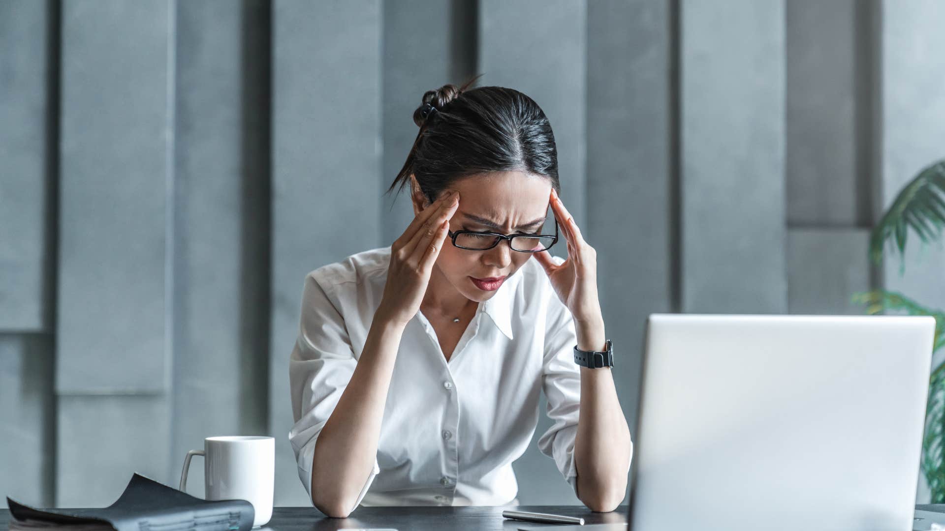 stressed employee at desk wearing too many hats