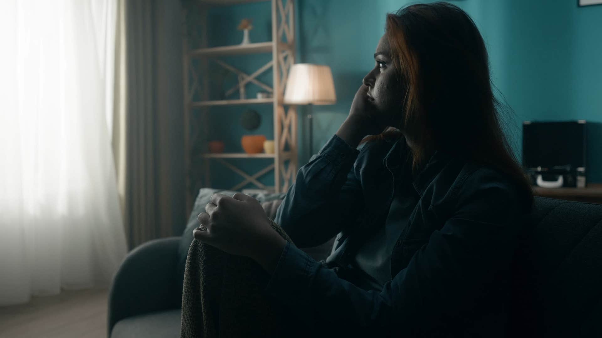 sad woman sitting in a room with no natural light