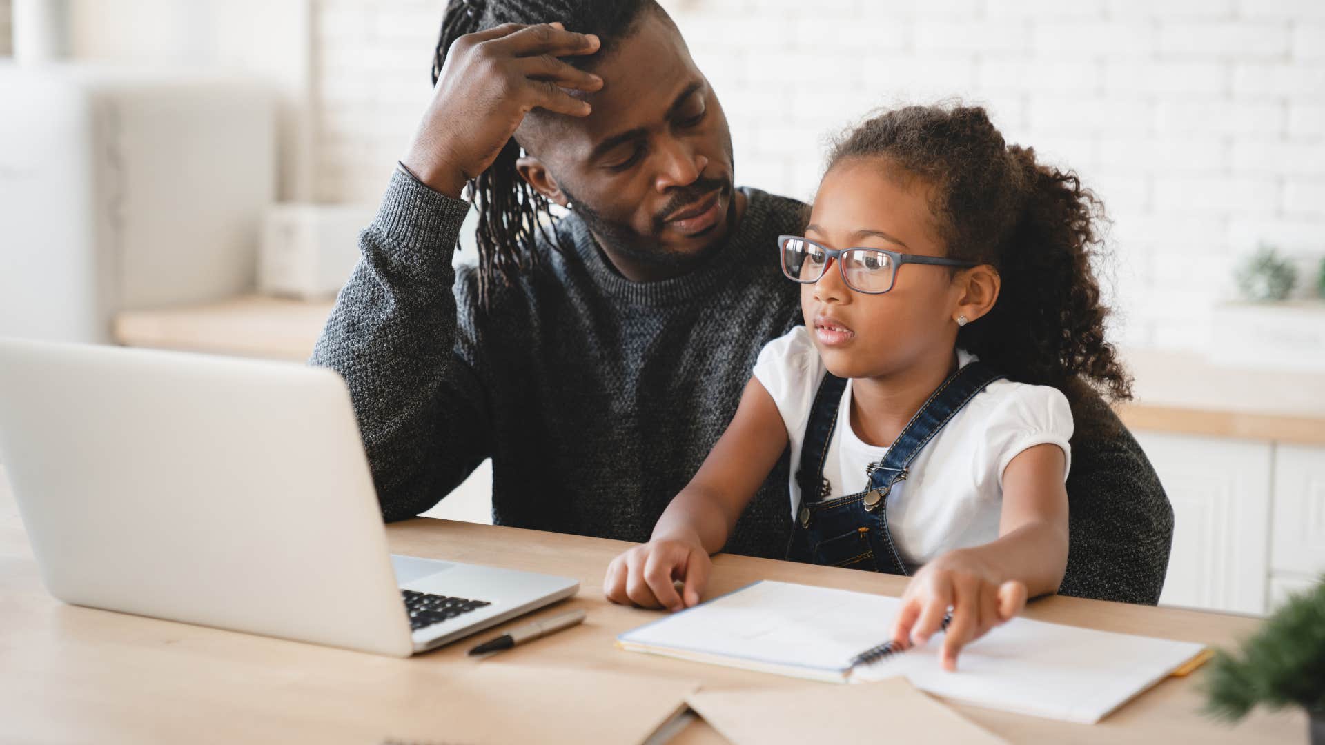 good dad helping daughter with schoolwork and listening to her