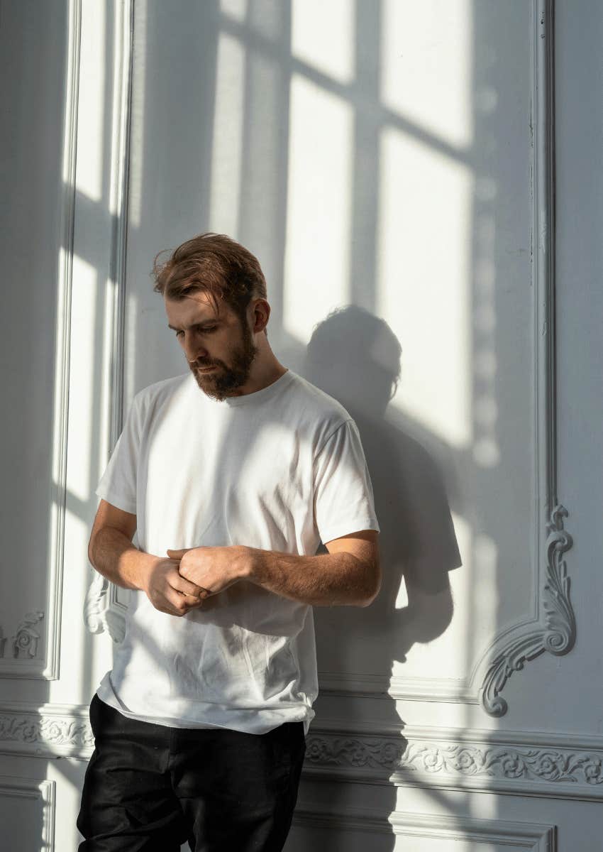 insecure man standing against a wall