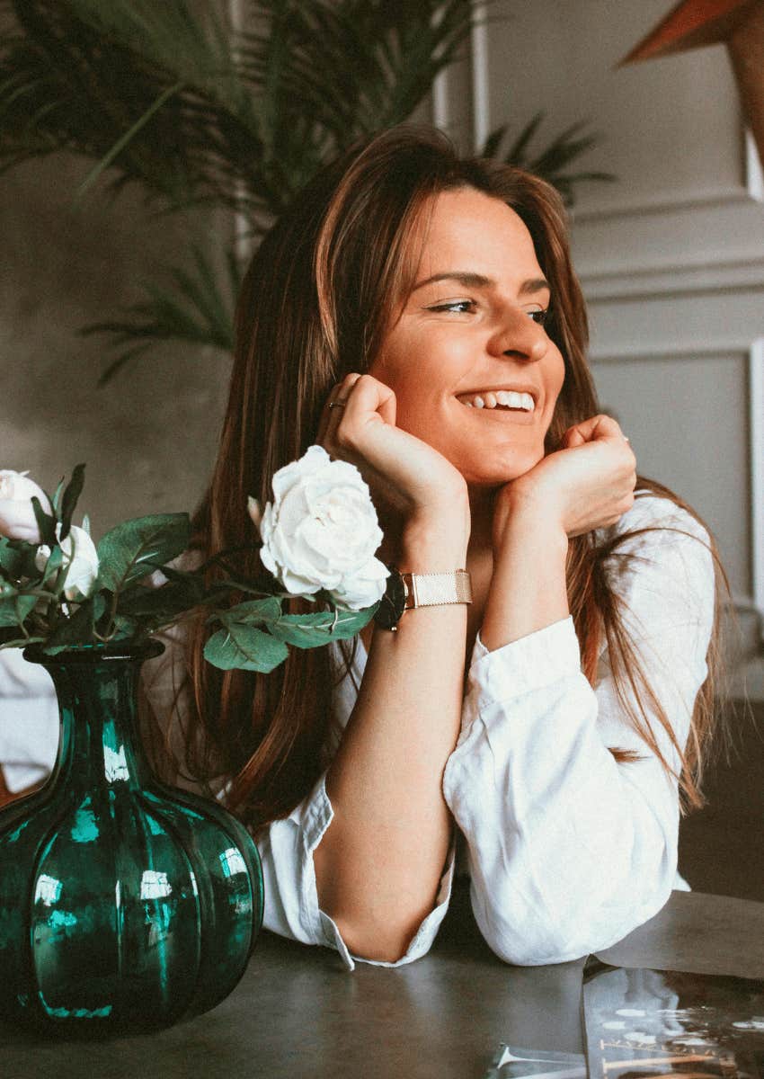 joyful woman resting her face in her hands