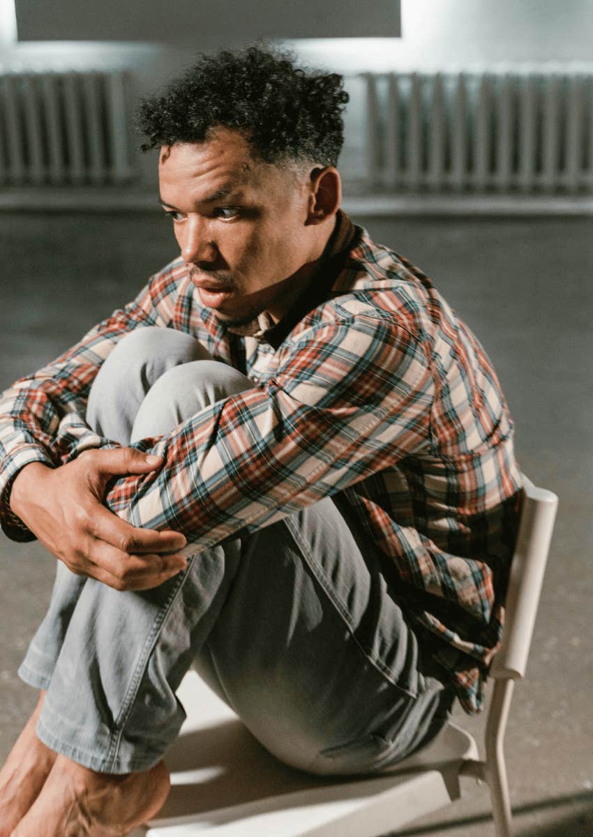 lonely man hugging his knees to his chest