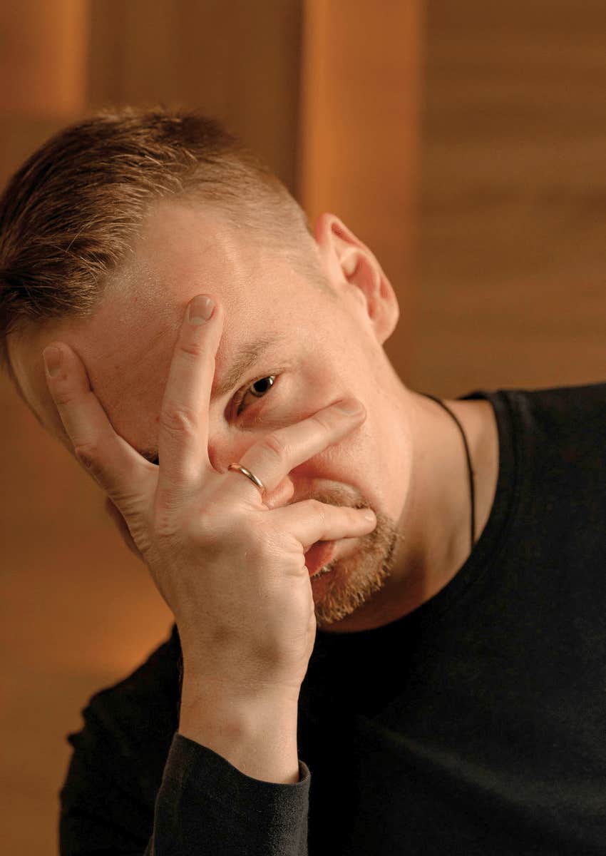 man hiding his face with his own hand 