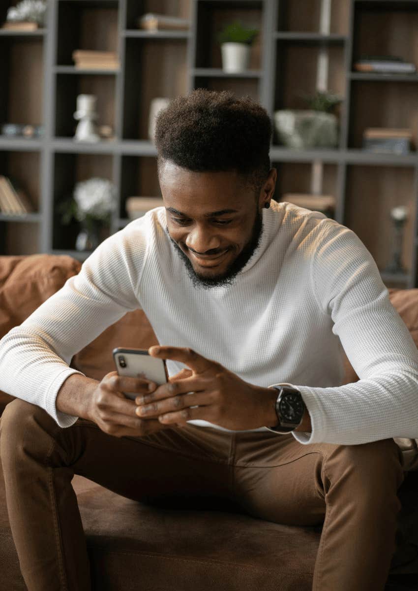 man smiling down at his phone