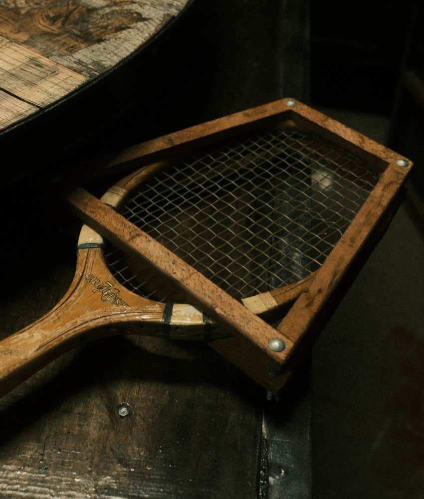 Vintage tennis racket showing memory of battle