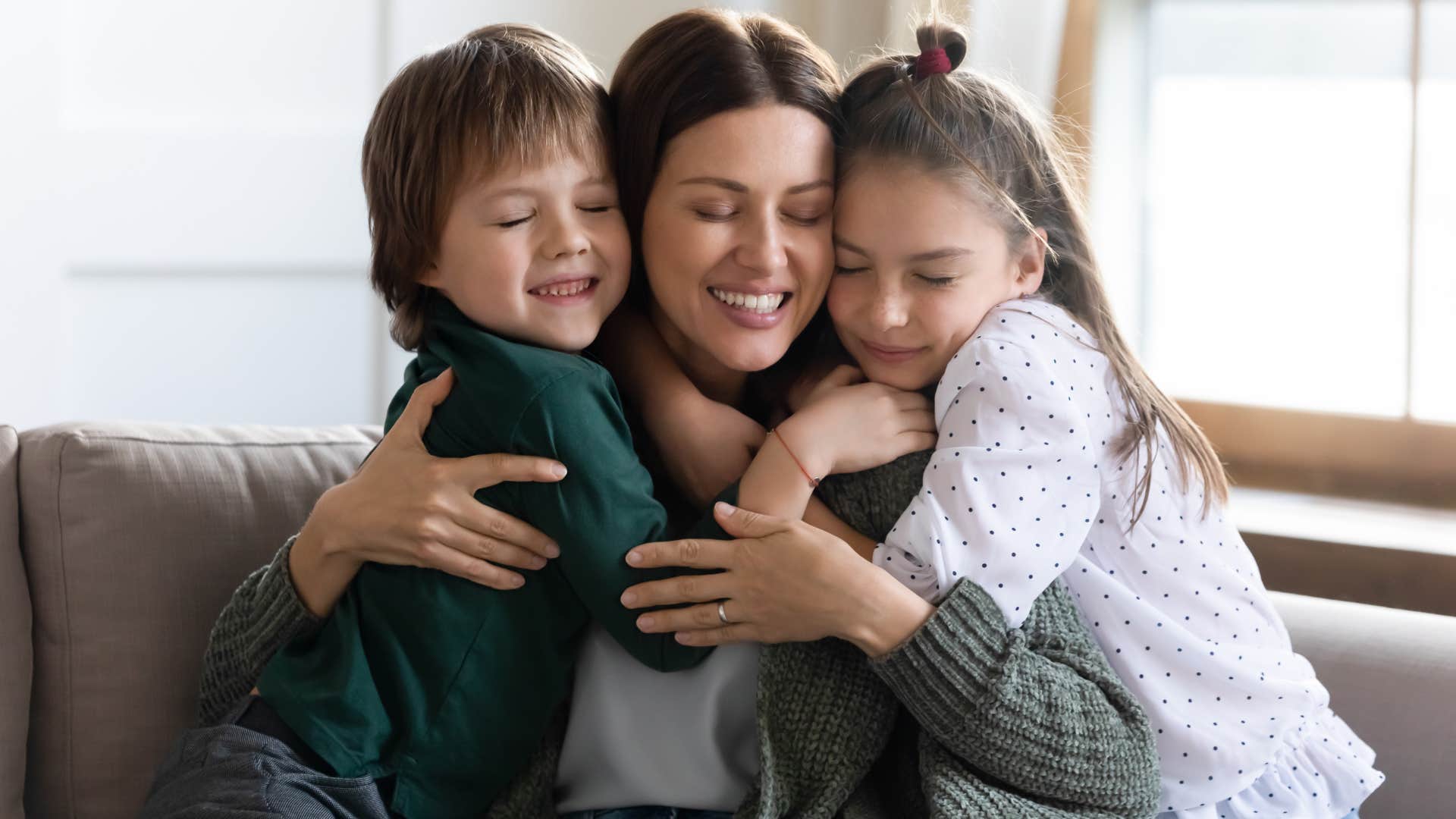 babysitter and kids smiling and snuggling