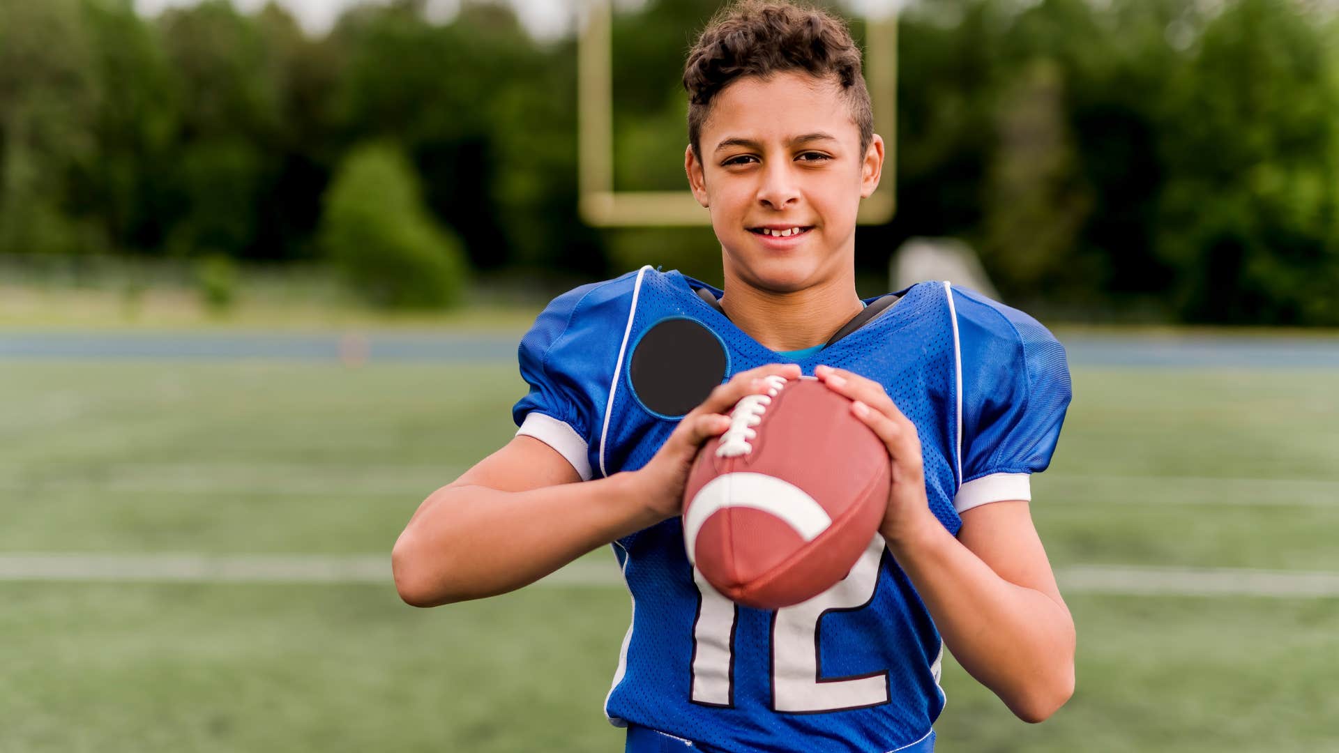 kid playing recreational sports football outside
