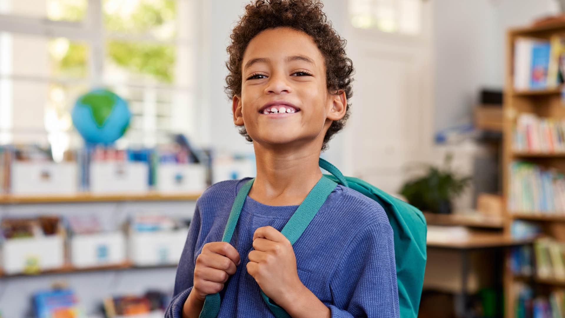 little boy smiling in library at school