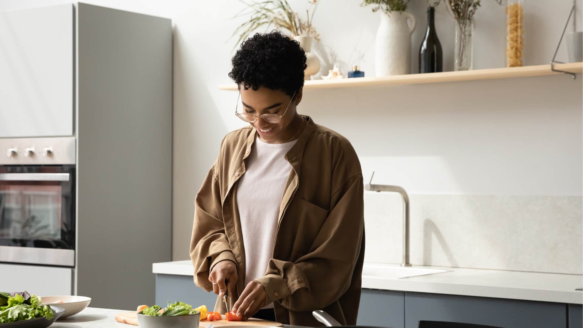 Happy millennial prepares meal showing way to deal with stress and struggle