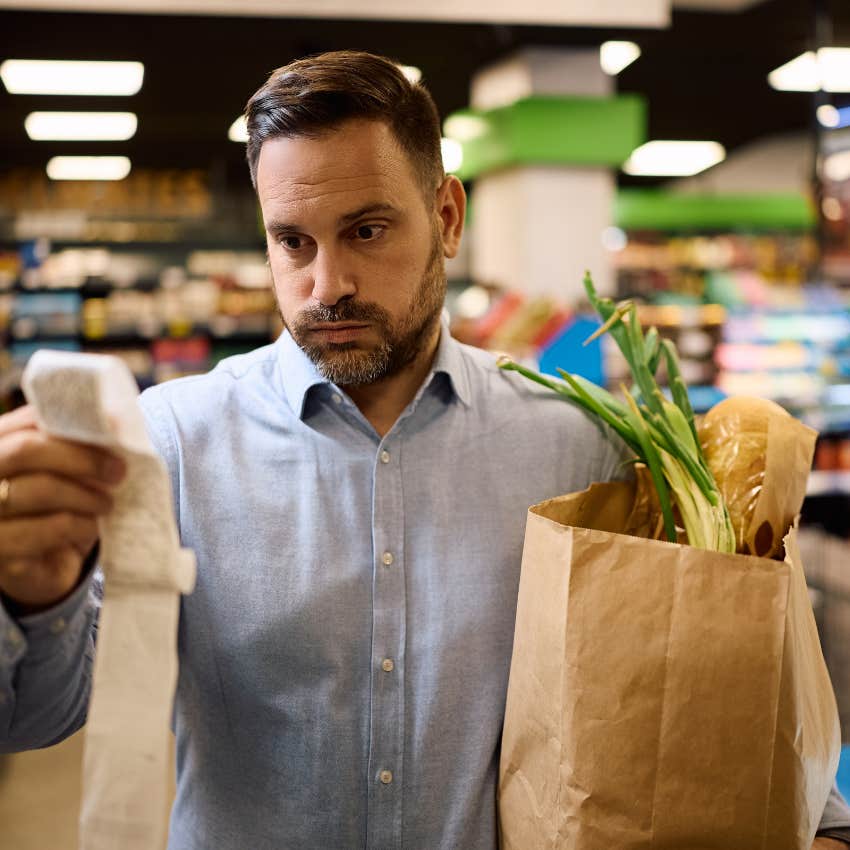Man struggling to afford groceries looking at receipt