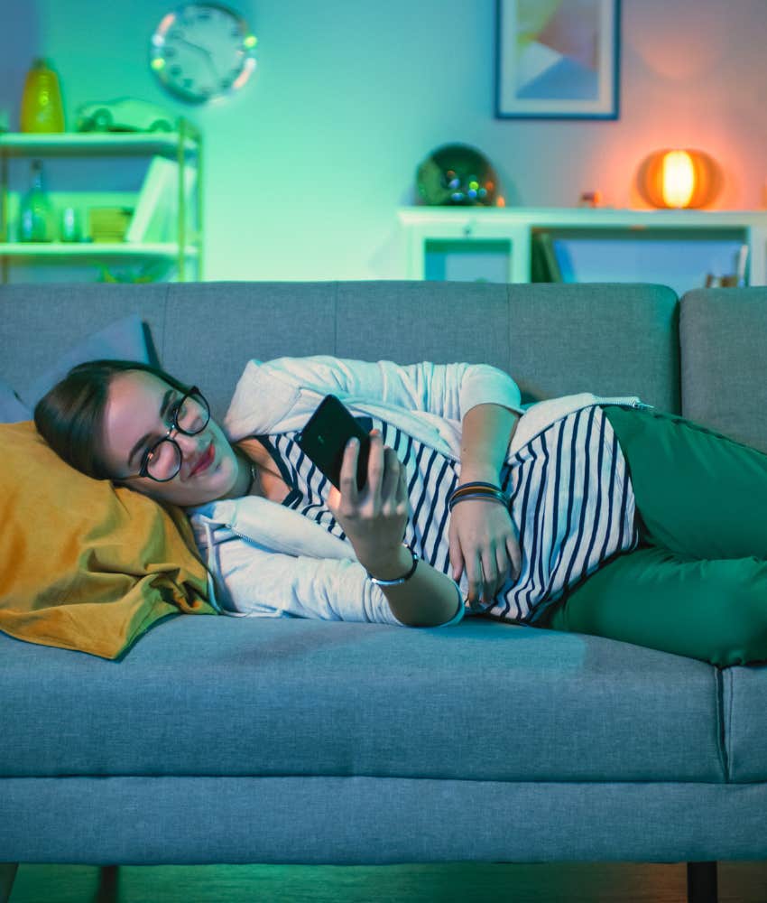 woman looking at her phone while watching movie