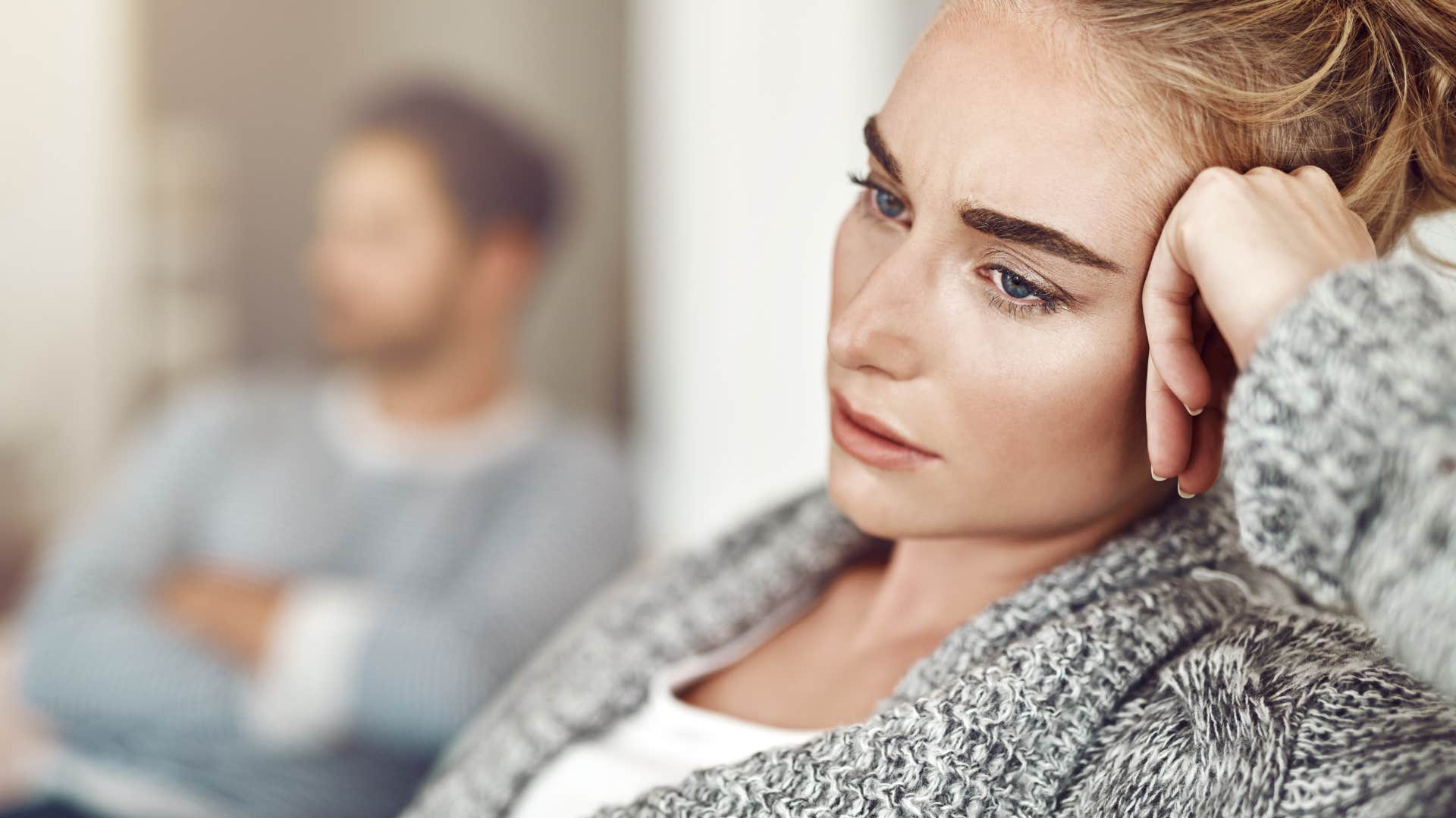 upset woman sitting away from partner after fight