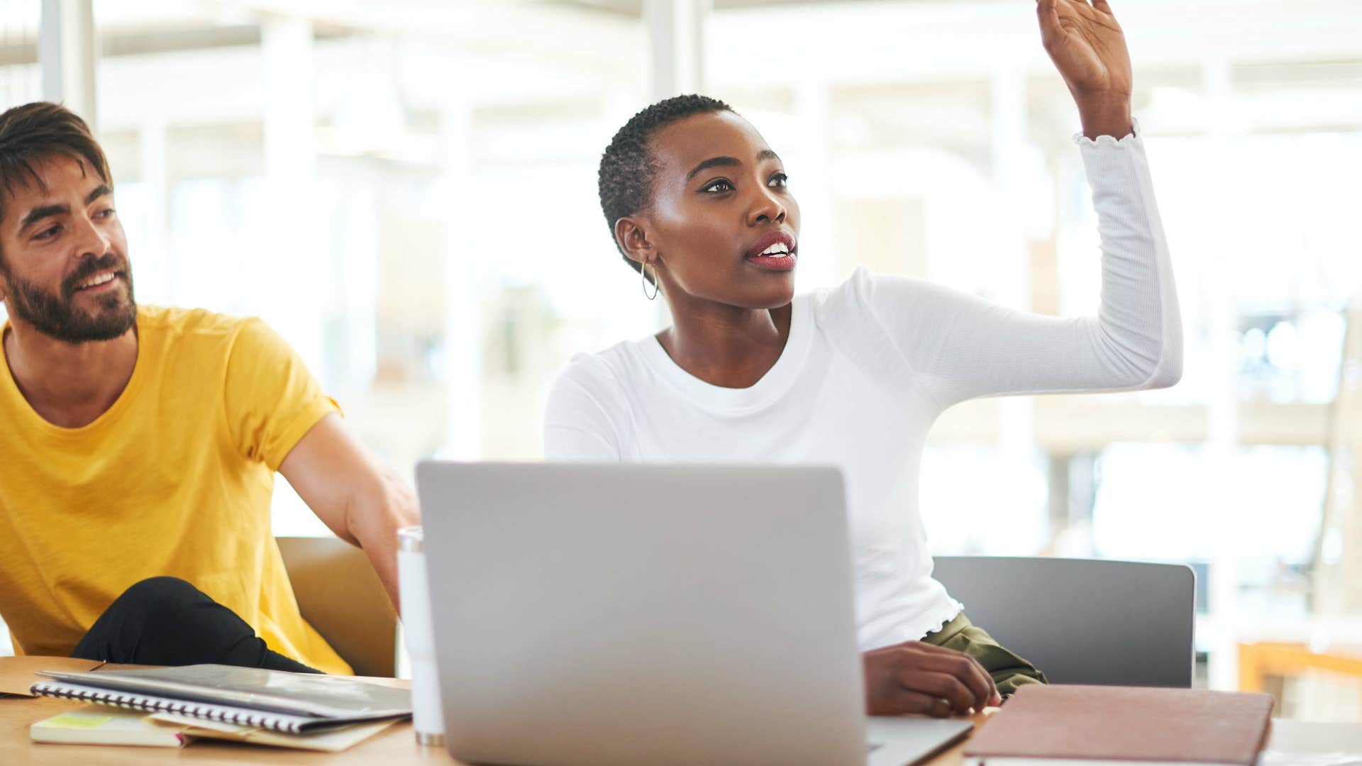 woman raising her hand to ask question